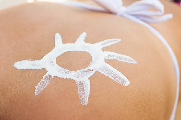 istock Woman With Sun Shaped Suntan Lotion On Back 468454172