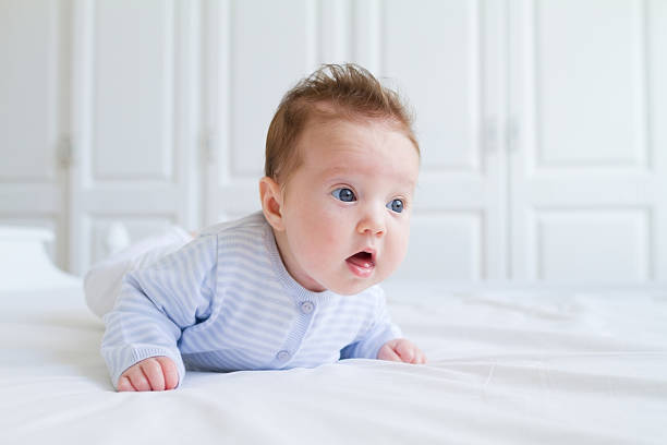 istock Funny baby tummy time in a white nursery 468457015