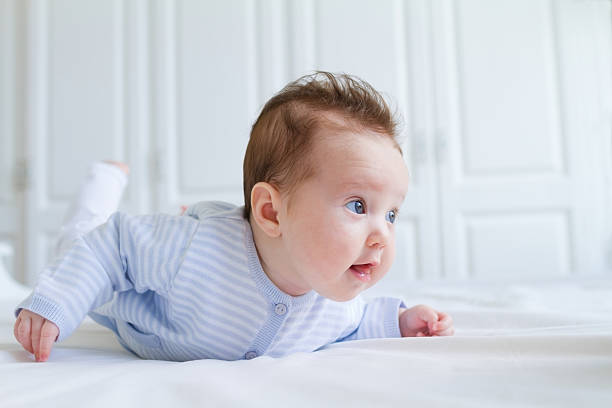 sonriente bebé de estómago tiempo en un blanco nursery - new wool fotografías e imágenes de stock