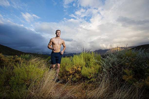 modelo de fitness masculino em execução allong um rasto no campo - fashion men fashion model male imagens e fotografias de stock