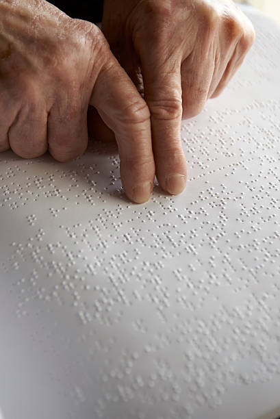 istock Old womans hands, reading a book with braille language 468460813