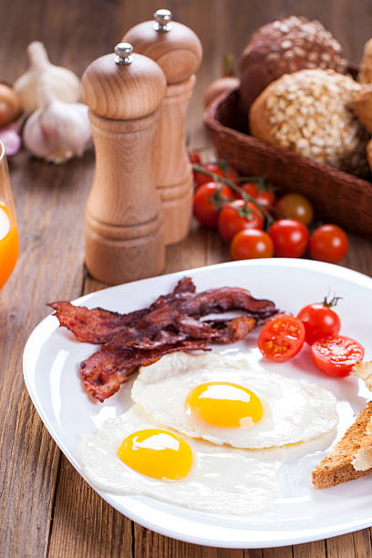 istock Delicious fried egg with spices, bacon, croutons and tomatoes on 468461154