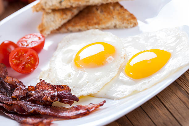 istock Delicious fried egg with spices, bacon, croutons and tomatoes on 468461156