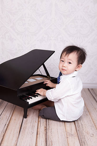 istock Cute baby boy playing toy piano 468461568