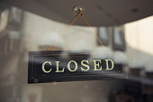 Hanging Closed sign behind glass