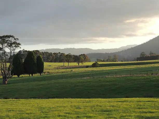 The beautiful play of light and shadows over Tasmania fields and mountains at sunset.