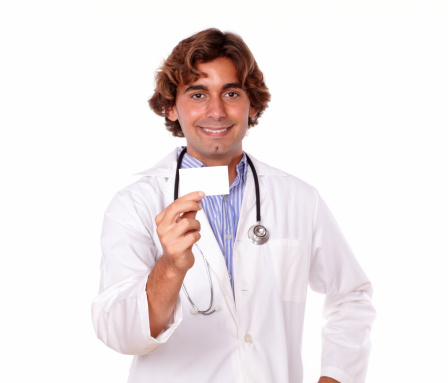 Portrait of a hispanic looking doctor in white uniform holding a blank business card in a white background - copyspace