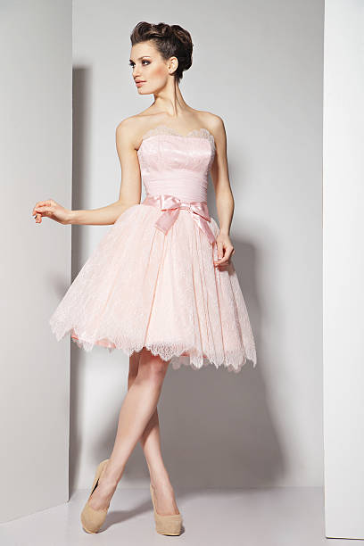 istock young beautiful brunette in pink dress on white 468467607
