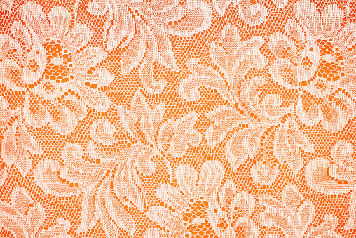 Peach lace sits on a oreng background