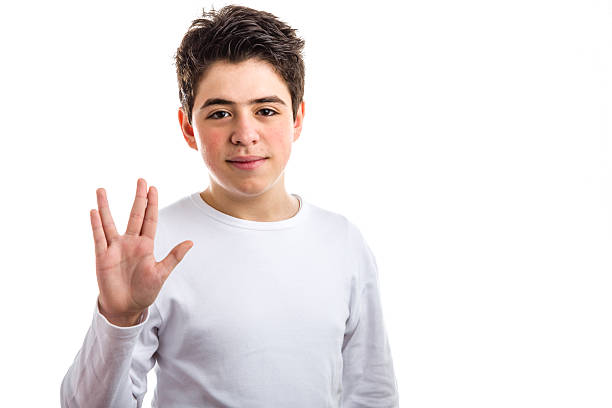 Vulcan salute by Caucasian boy with acne-prone skin. Caucasian boy with acne-prone skin in a white long sleeved t-shirt makes vulcan salute vulcan salute stock pictures, royalty-free photos & images