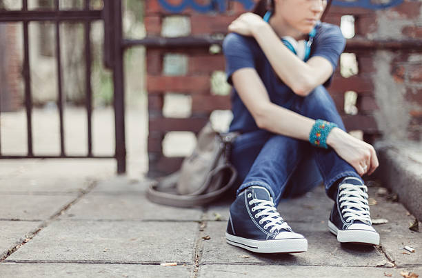 istock Unhappy girl sitting on ground 468482462