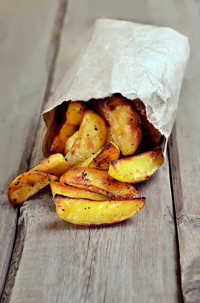 istock Fried potato wedges in paper bag 468482944