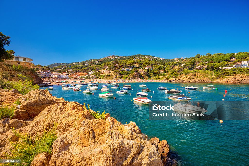 Summer at the Costa Brava - Sa Riera Beach, Begur The beautiful beach of Sa Riera (Begur) at the Costa Brava, crowded with private boats and tourist, on a sunny summer day in August. Gerona Province Stock Photo