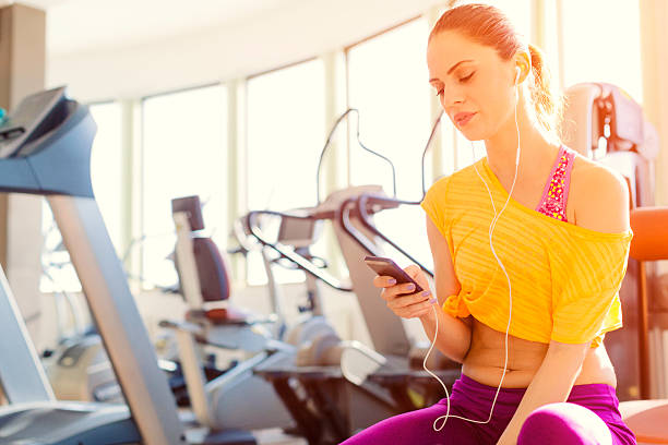 istock Woman using smart phone in a gym. 468483688