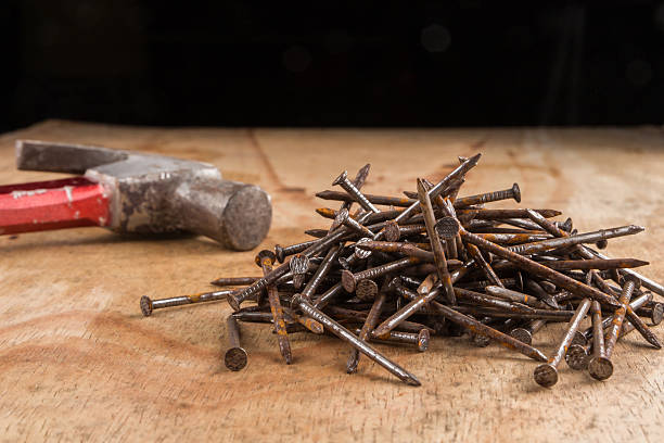 istock Hammer head and nails on a wooden table 468492324