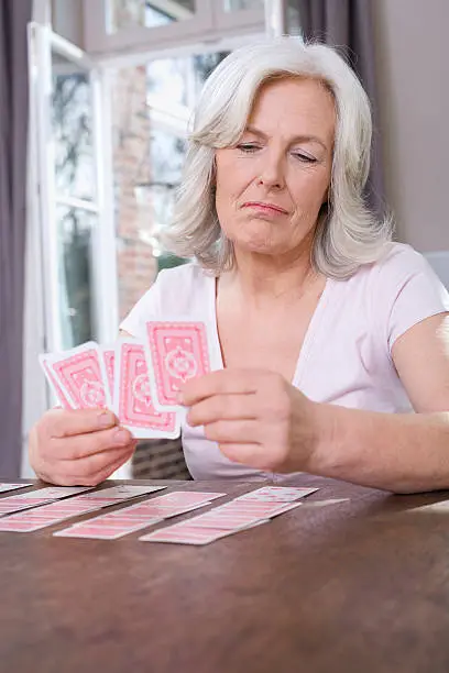 Senior woman playing Solitaire at home