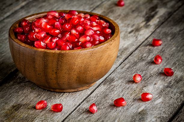 istock ruby pomegranate grains in a wooden bowl on a table 468500400