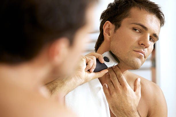 riflessione di giovane uomo in specchio da barba con rasoio elettrico - shaving men electric razor reflection foto e immagini stock