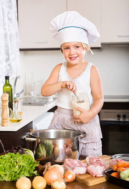 piccola ragazza cucinare cibo europea - preparation meat single object female foto e immagini stock