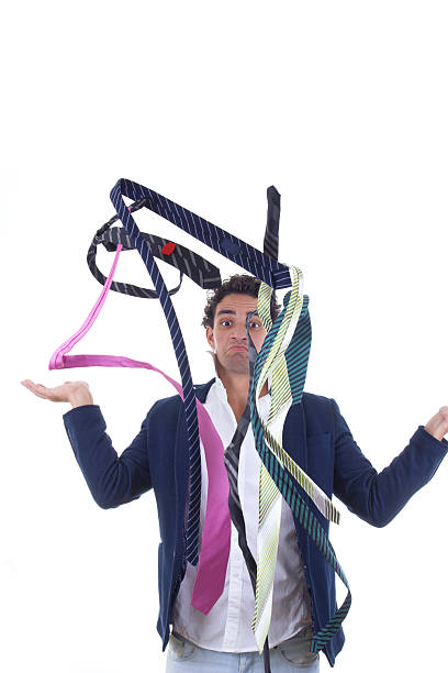 undecided man with lot of ties around him stock photo