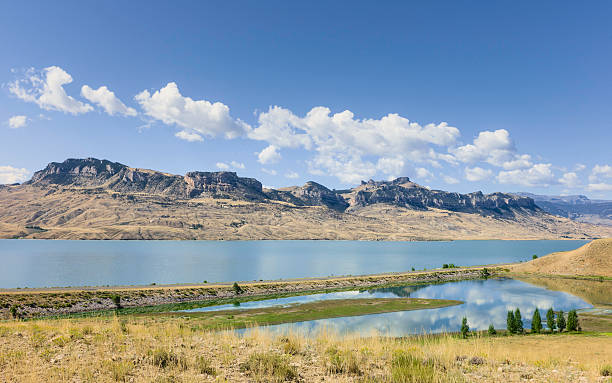 Buffalo Bill State Park, Cody, Wyoming, USA. Cody, Wyoming, USA - View across Bufflao Bill State park showing the reservoir, the rugged landscape and dry bush land in the height of summer under a bright blue sky near Cody, Wyoming, USA. wyoming stock pictures, royalty-free photos & images