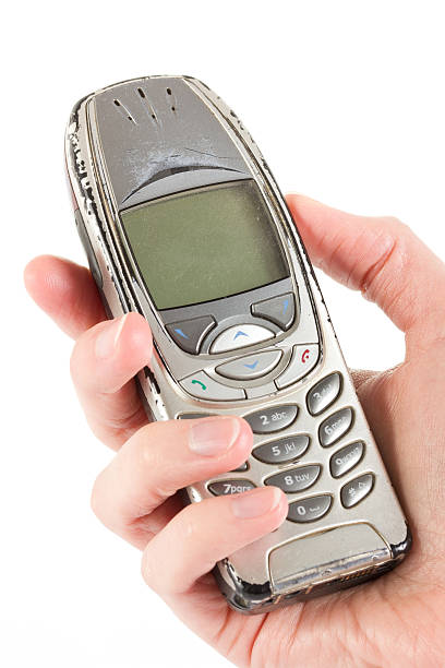 istock An old worn out cell phone being held over white 468518890