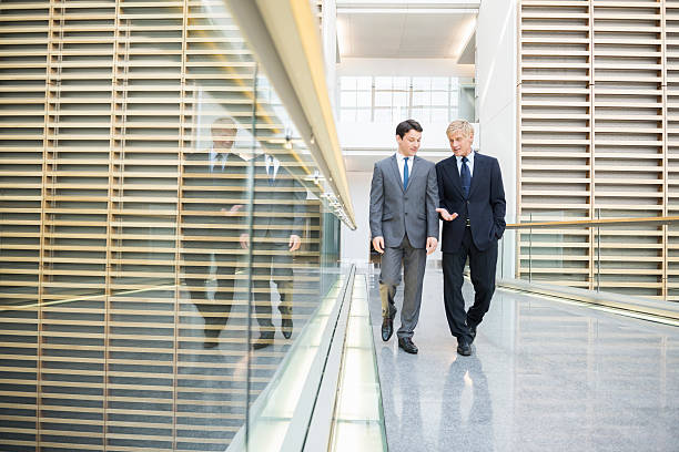 istock Businessmen Discussing While Walking In Office 468525798