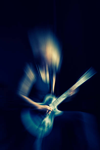 istock girl playing rock guitar blurred ,rock background 468533712