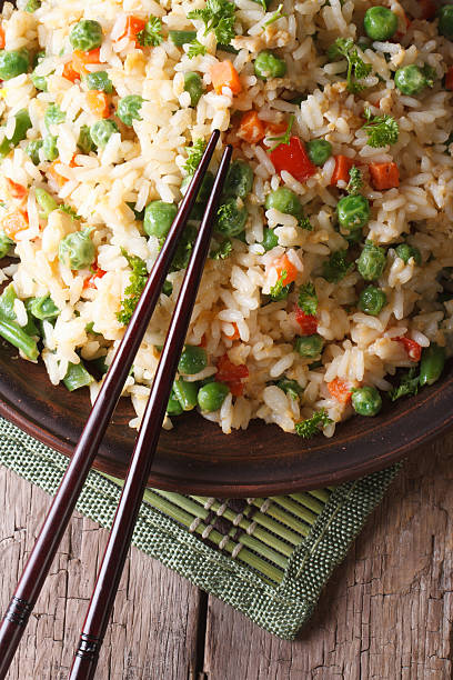 istock fried rice with egg, peas, carrots close-up vertical top view 468534430