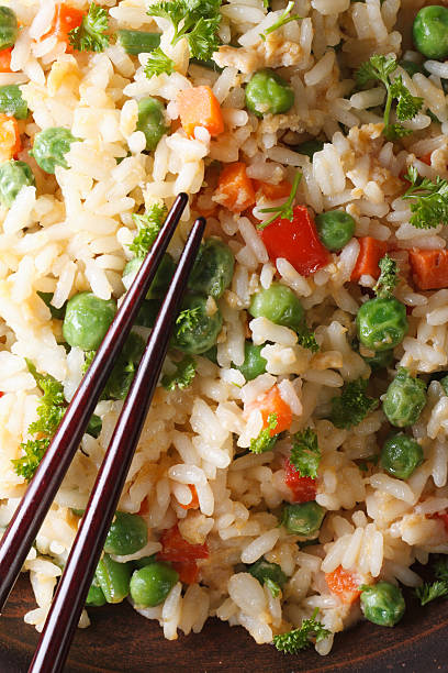 istock fried rice with egg, peas, carrots macro vertical top view 468534432
