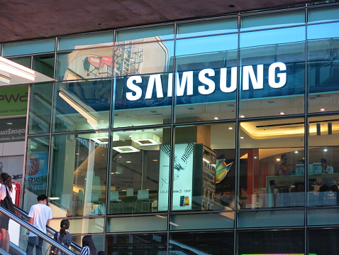 Bangkok, Thailand – April 27, 2014: Exterior view of a Samsung shop in the Siam Square area of Bangkok, Thailand. People can be seen inside the store. Some are outside the store. The picture is taken from the sidewalk. 