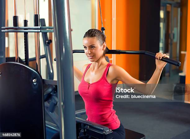 Hermosa Joven Haciendo Ejercicio En Un Gimnasio Foto de stock y más banco de imágenes de Mujeres jóvenes - Mujeres jóvenes, 2015, Actividades y técnicas de relajación