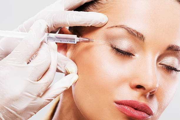 mujer con los ojos cerrados que reciben inyección de botox. - attractive female human collagen syringe injecting fotografías e imágenes de stock