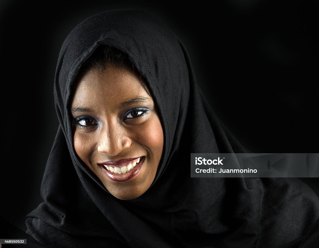 Smiling muslim teenage girl Smiling muslim teenage girl posing on black background  (this picture has been taken with a Hasselblad H3D II 31 megapixels camera) Nigeria Stock Photo