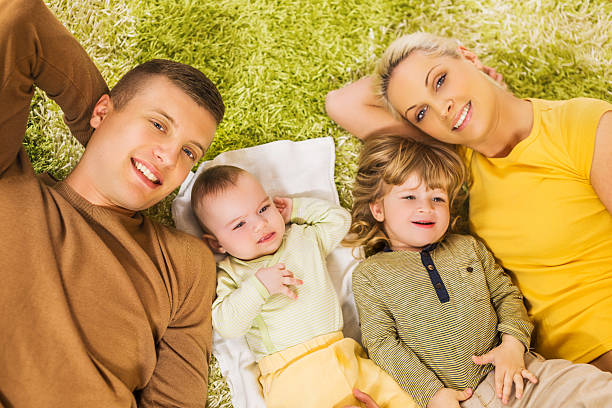 vista de ângulo elevado de jovem feliz família deitada no tapete. - couple loving lying on back carpet imagens e fotografias de stock