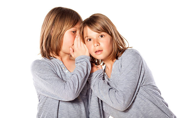 istock boy whispering  to his twin 468557698