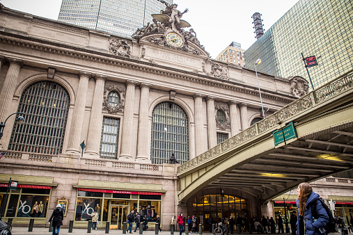 New York City, New York, USA - February 21, 2015:  View outside historic Grand Central Terminal at Pershing Square in midtown Manhattan with people visible. This landmark transportation hub opened its doors in 1913.