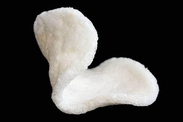 istock Detail of single prawn cracker on black. 468558838