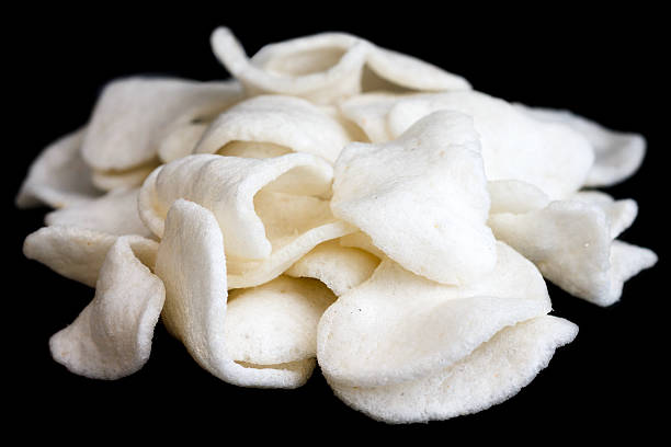 istock Pile of prawn crackers on black. 468558954