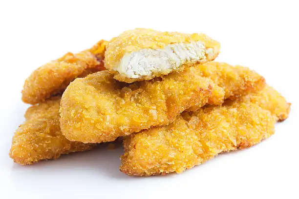 Photo of Golden fried chicken strips on white.