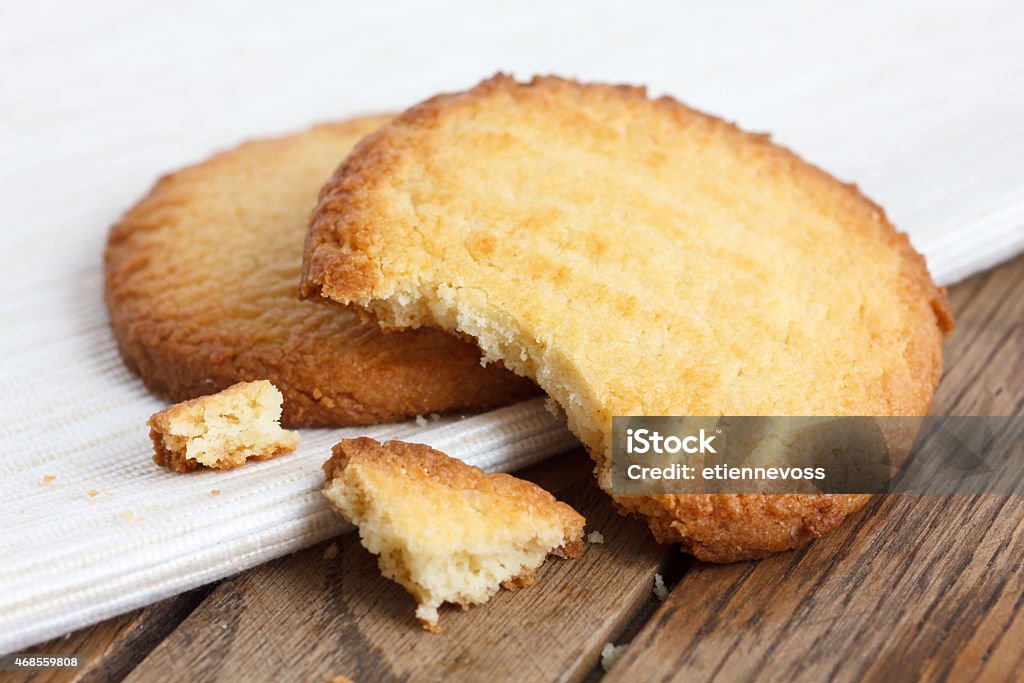 Two butter biscuits on napkin and wood. Broken. Cookie Stock Photo
