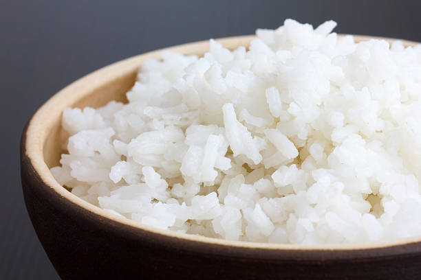 istock Rustic bowl of cooked white rice on dark surface. Detail. 468559836