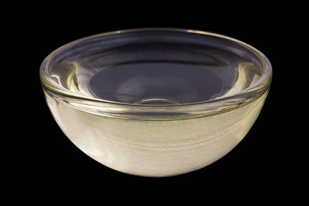 istock Vegetable oil in small glass dish. Black background. 468563542