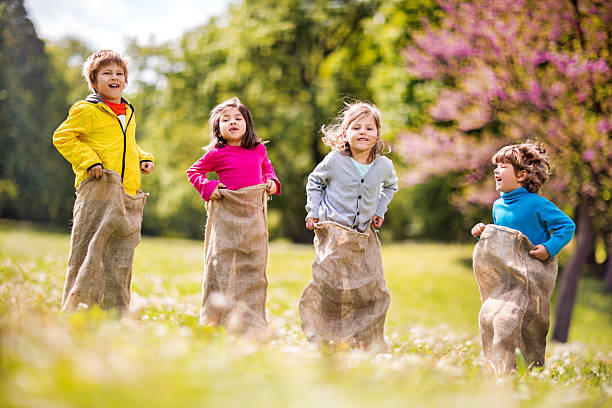 istock Happy children having sack race in the park. 468567682