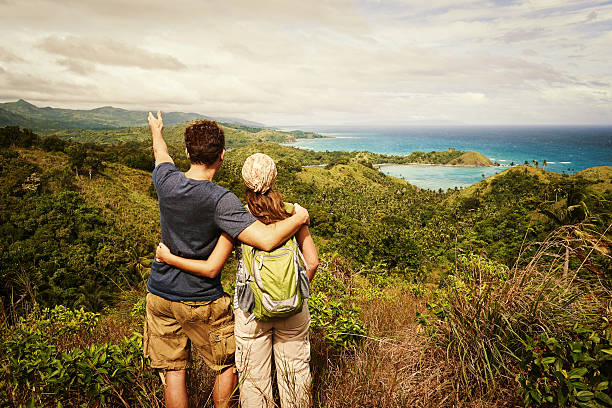 istock Two hikers with backpack standing top of mountain and looking 468568046