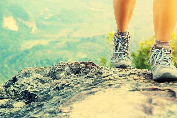 istock hiking woman legs climbing on mountain peak 468576412