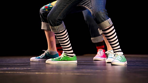 Feet of a trio of hip-hop performer in colorful sneakers stock photo