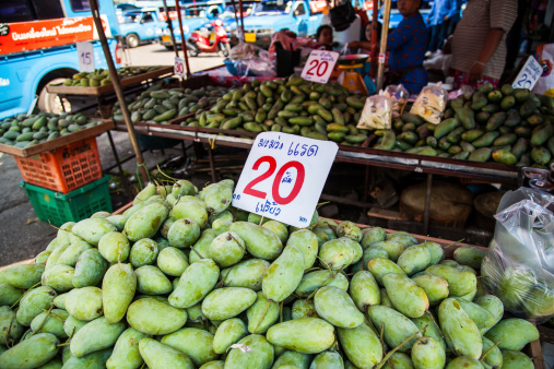 Chiang Rai, Thailand - May 2, 2013: The shop staff selling green mango fruits at the central market in Chiang Rai, Thailand.