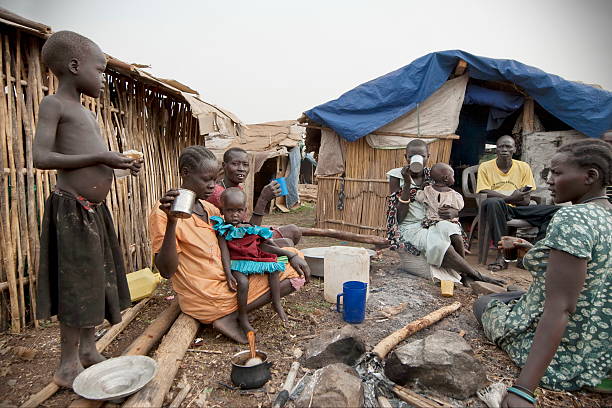 People have breakfast in displaced persons camp, Juba, South Sudan. Juba, South Sudan - February 28th, 2012: Unidentified people have breakfast in front of their huts in displaced persons camp, Juba, South Sudan, February 28, 2012. south sudan stock pictures, royalty-free photos & images