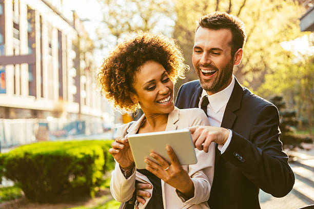 istock Two business people using digital tablet together outdoor 468582340